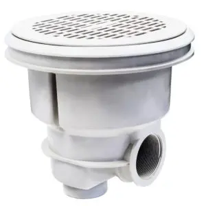 Scarico di fondo rotondo di colore bianco, presentato su uno sfondo bianco. Lo scarico ha una forma circolare con una superficie superiore piatta e un corpo cilindrico sottostante. La superficie superiore presenta una griglia con numerosi piccoli fori rettangolari disposti in cerchi concentrici e linee radiali. La griglia è leggermente rialzata rispetto al bordo esterno, che è piatto e liscio. Sul bordo esterno della superficie superiore sono visibili due fori, posizionati diametralmente opposti, destinati all'inserimento di viti per il fissaggio al fondo della piscina. La parte inferiore dello scarico mostra un corpo cilindrico con un raccordo filettato laterale per il collegamento al sistema di tubazioni della piscina. L'interno del raccordo laterale presenta una filettatura ben definita. L'intero componente è realizzato in materiale plastico di colore bianco. Il design con la griglia fitta e i fori rettangolari è tipico degli scarichi di fondo per piscina, progettati per garantire un'aspirazione sicura ed efficiente dell'acqua.