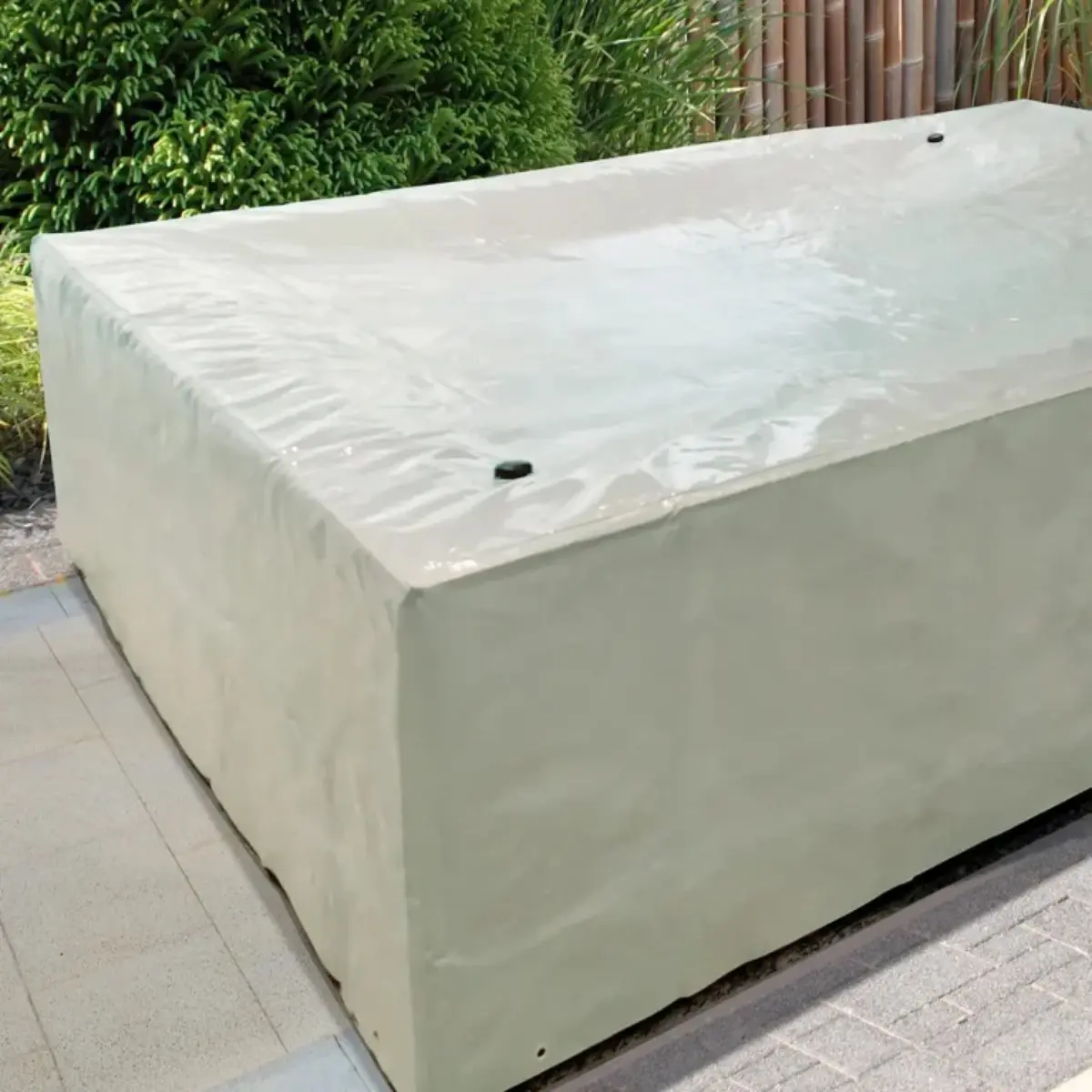 Telo di copertura standard per piscina Laghetto Playa Una Playa con struttura fuoriterra coperta dal telo di copertura standard per piscine laghetto playa. Il telo è di grigio chiaro è realizzato in un materiale impermeabile e resistente alle intemperie. Copre completamente la Playa proteggendola da pioggia, sole e sporco. Sul telo si notano delle cuciture e dei rinforzi, che suggeriscono una buona qualità e resistenza. L'immagine trasmette una sensazione di protezione e cura. Il telo protettivo suggerisce che la piscina è stata preparata per essere lasciata all'esterno durante un periodo di inutilizzo o maltempo. L'ambiente circostante, con la pavimentazione esterna e le piante, indica che la piscina si trova in un giardino o in un patio.