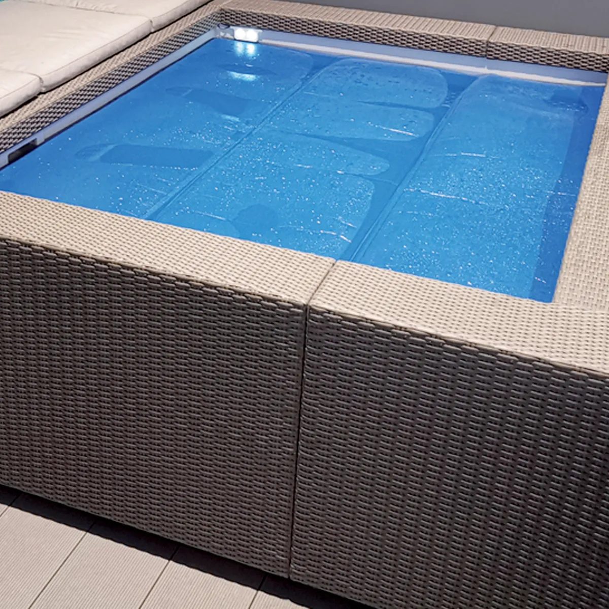 Telo isotermico Playa istallato su piscina Minipiscina Playa colore bianco con posizionata sopra acqua telo di copertura isotermico blu.