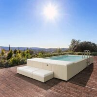 Piscina fuori terra Laghetto Divina con rivestimento in fibra sintetica intrecciata effetto rattan colore bianco. Presentata in un contesto outdoor elegante.