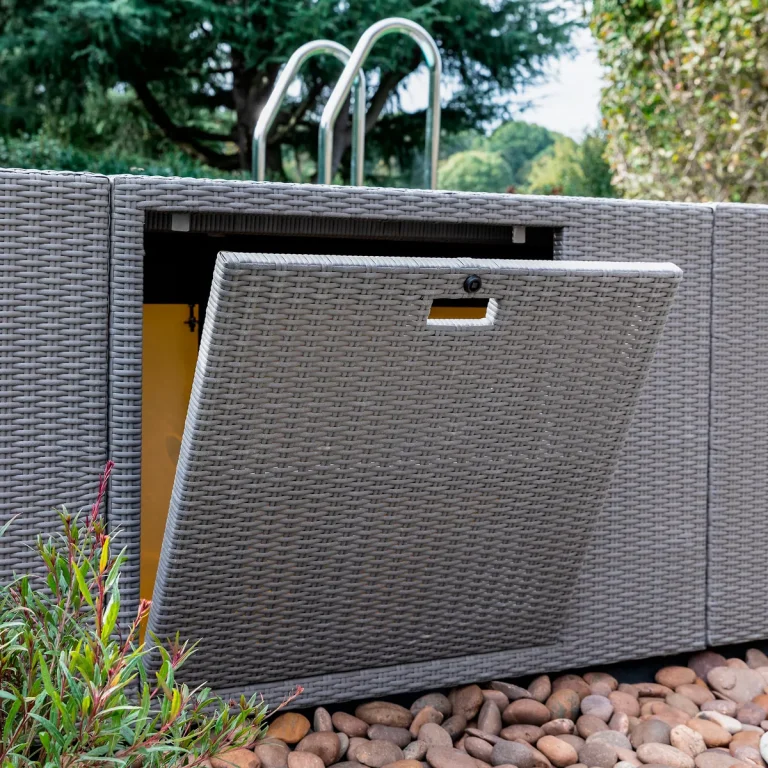 Piscina fuori terra Laghetto Divina con rivestimento in fibra sintetica intrecciata effetto rattan colore grigio. Particolare sportello controllo locale tecnico.
