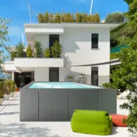 Piscina fuori terra Laghetto Dolcevita Diva con rivestimento in fibra sintetica intrecciata effetto rattan colore grigio. Presentata in un contesto outdoor elegante.